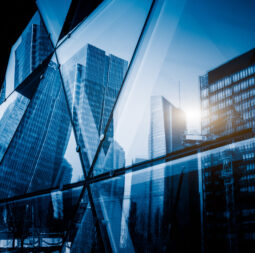 View,Of,A,Modern,Glass,Skyscraper,Reflecting,The,Buildings,Around,blue