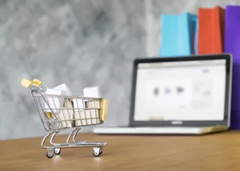 Business theme, internet online shopping concept, shopping delivery, shopping cart carry shopping mail box and blur background of shopping bag and open laptop